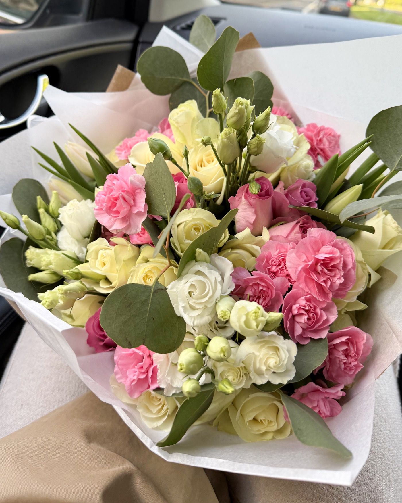 Pink and cream bouquet in a car