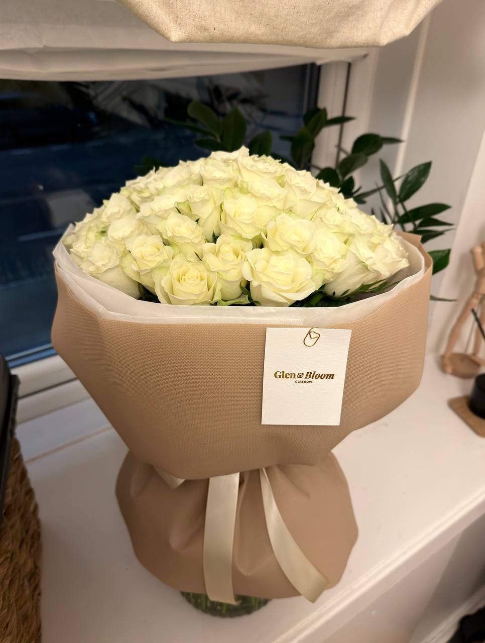 White roses wrapped in beige paper